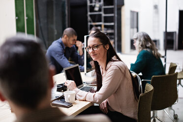 Männliche und weibliche Geschäftskollegen diskutieren bei einem Treffen am Tisch in einem kreativen Büro - MASF07681