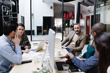 Business colleagues discussing in meeting while using technologies at creative office - MASF07708