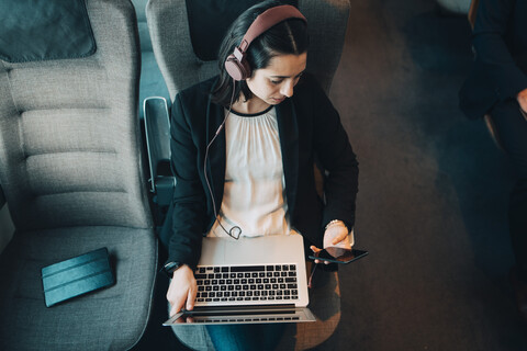 High angle view of businesswoman using various technologies while traveling in train stock photo