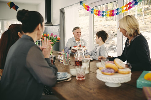 Familie am Tisch sitzend während einer Geburtstagsfeier - MASF07931