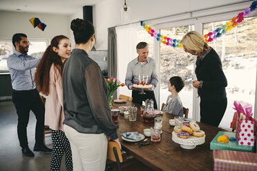 Großvater zeigt dem Jungen den Geburtstagskuchen, während die glückliche Familie auf der Party genießt - MASF07933