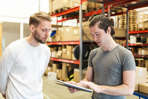 Männliche Kollegen diskutieren über ein digitales Tablet in der Industrie - MASF07993