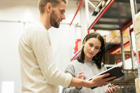 Tiefblick auf Kollegen, die über ein digitales Tablet in der Industrie diskutieren - MASF08000