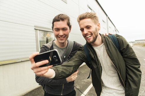 Lächelnde Mitarbeiter machen ein Selfie mit ihrem Handy außerhalb der Industrie - MASF08004