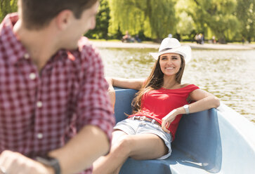 Happy young couple rowing on boating lake in Regents Park, London, UK - CUF20902