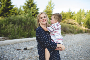 Mittlere erwachsene Frau trägt und umarmt ihren kleinen Sohn am Ontariosee, Oshawa, Kanada - CUF20918