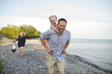 Father giving daughter a piggy back at Lake Ontario, Oshawa, Canada - CUF20919