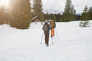 Pärchen beim Schneeschuhwandern durch verschneite Landschaft, Rückansicht, Elmau, Bayern, Deutschland - CUF20924