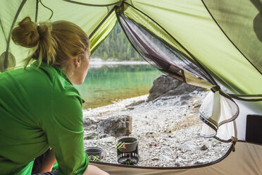 Woman in tent by water, Leermoos, Tyrol, Austria - CUF20952