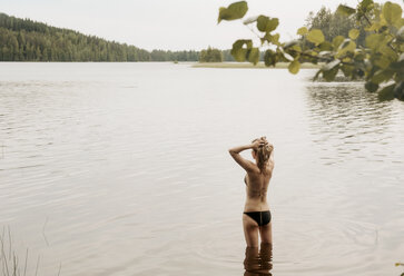 Rückansicht einer Frau mit Händen im Haar im See, Orivesi, Finnland - CUF21009