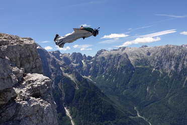 Wingsuit BASE Jumper fliegt von einer Klippe Italienische Alpen, Alleghe, Belluno, Italien - CUF21014