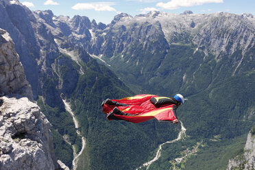 Wingsuit-BASE-Springer, der an der Felswand entlang und das Tal hinunter fliegt, Italienische Alpen, Alleghe, Belluno, Italien - CUF21023