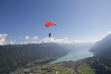 Männlicher Fallschirmspringer mit Fallschirm über dem See, Interlaken, Bern, Schweiz - CUF21025