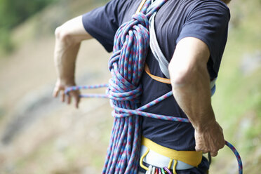 Cropped view of rock climber carrying climbing rope on back - CUF21032