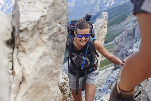 Woman hiking up mountain smiling, Austria - CUF21059