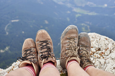 Cropped view of hikers feet wearing hiking books on rocks, Austria - CUF21064