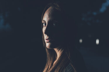 Portrait of young freckled woman with nose piercing at night - CUF21121