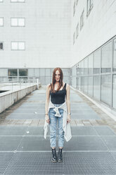 Porträt einer jungen Frau, die vor einem Bürogebäude steht - CUF21135