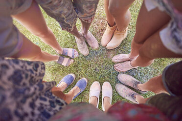 Gruppe von Freunden auf einem Fest, bedeckt mit bunter Pulverfarbe, im Kreis stehend, Blick auf die Füße von oben - CUF21185