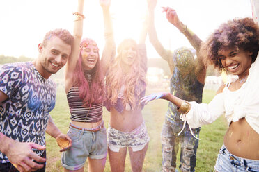 Group of friends at festival, covered in colourful powder paint - CUF21189