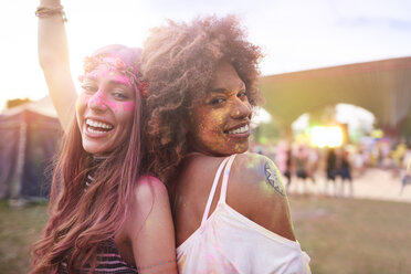 Porträt von zwei Freundinnen auf einem Festival, bedeckt mit bunter Pulverfarbe - CUF21190
