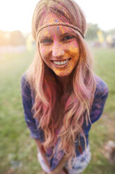 Portrait of young woman at festival, covered in colourful powder paint - CUF21193