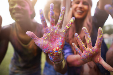 Group of friends at festival, covered in colourful powder paint - CUF21195