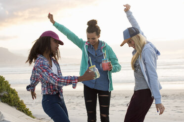 Drei junge Freundinnen tanzen zusammen am Strand, Kapstadt, Westkap, Südafrika - CUF21204