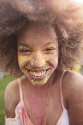 Portrait of young woman at festival, covered in colourful powder paint - CUF21222