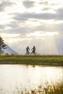 Austria, Tyrol, Mountainbikers in the evening light - CVF00645