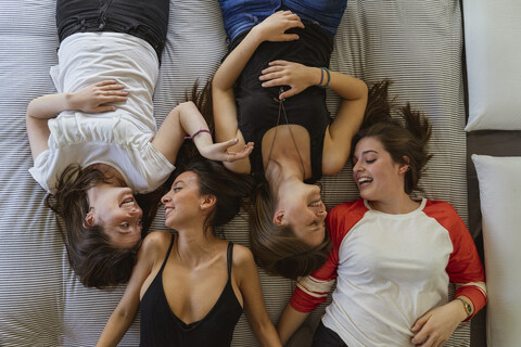 Vier Freunde entspannen sich auf der Couch zu Hause, lizenzfreies Stockfoto