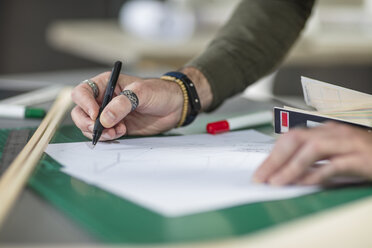 Close-up of man drawing at desk in office - ZEF15541