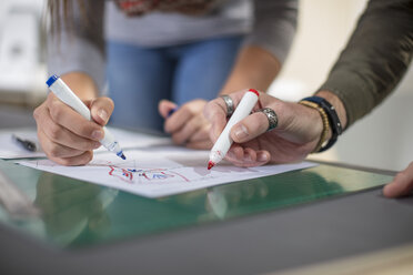 Close-up of two colleagues drawing at desk in office - ZEF15547