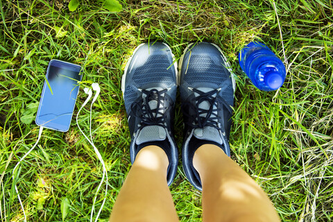 Laufschuhe, Smartphone mit Kopfhörern, Wasserflasche, Blick von oben, lizenzfreies Stockfoto