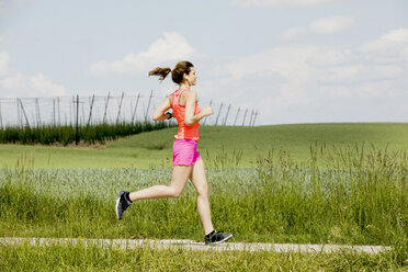 Sport Teenage Girl Running Outdoor. Young Woman Running In Field