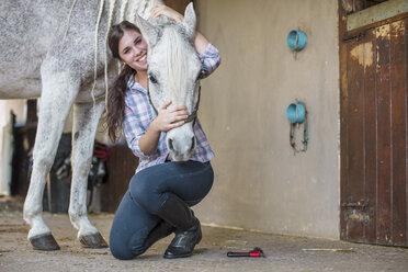 Porträt einer lächelnden Frau mit einem Pferd auf einem Bauernhof - ZEF15562