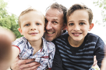 Selfie eines glücklichen Vaters mit zwei Söhnen im Freien - UUF13948