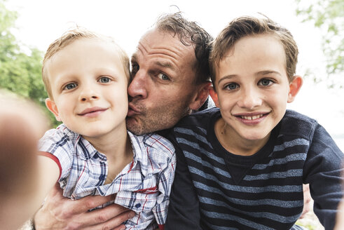 Selfie eines glücklichen Vaters mit zwei Söhnen im Freien - UUF13949
