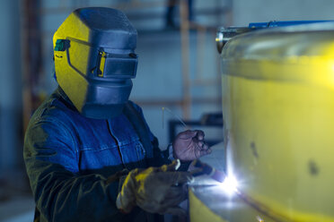 Welder in industrial plant welding tanks - ZEF15577