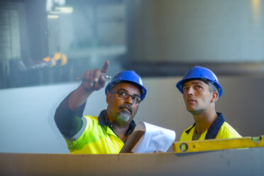 Engineers in industrial plant discussing work - ZEF15582