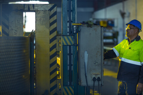 Ingenieur in einem Industriebetrieb, der Maschinen inspiziert, lizenzfreies Stockfoto