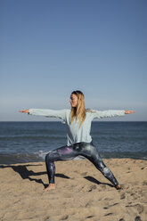 Frau beim Yoga am Strand, Kriegerpose - MAUF01428