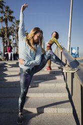 Sportliche Frau beim Training, Stretching auf Stufen - MAUF01434