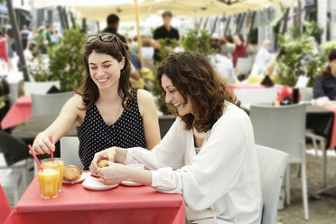 Zwei Frauen unterhalten sich und frühstücken in einem Straßencafé, Mailand, Italien - CUF21232