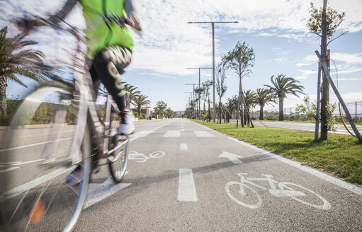 Unscharfe Nahaufnahme eines Radfahrers mit Warnweste auf dem Radweg - CUF21252