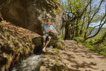 Mature sitting by stream, Meran, South Tyrol, Italy - CUF21290