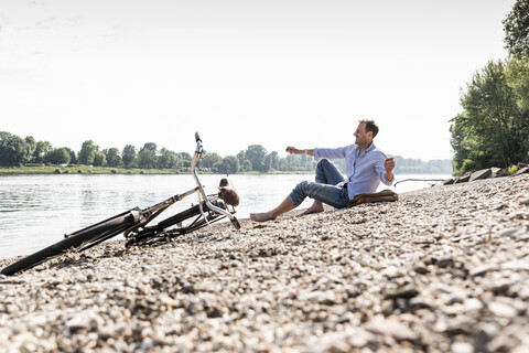 Älterer Mann mit Fahrrad am Rheinufer, lizenzfreies Stockfoto