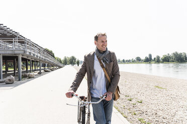Älterer Mann mit Fahrrad am Rheinufer - UUF13997
