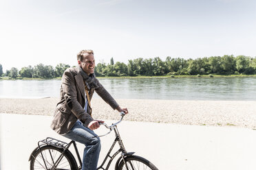 Älterer Mann mit Fahrrad am Rheinufer - UUF14008