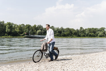 Älterer Mann mit Fahrrad am Rheinufer - UUF14015